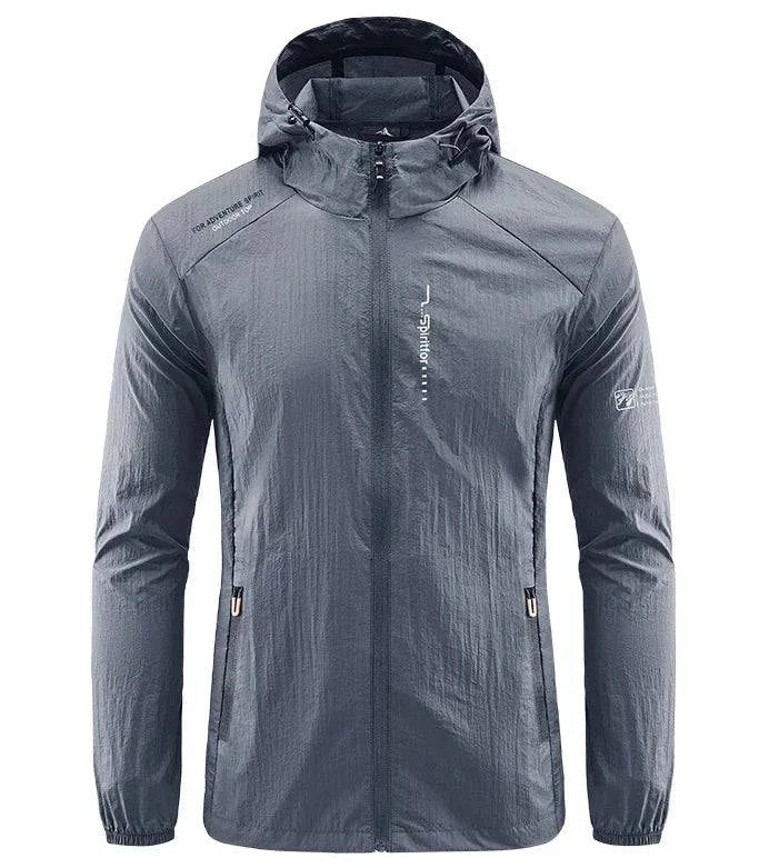 Jaqueta corta-vento esportiva masculina cinza grafite com capuz, ideal para proteção contra vento e chuva leve. Performance superior em qualquer aventura.