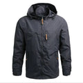 Jaqueta corta-vento masculina cinza chumbo com forro térmico, capuz e detalhes de zíper em couro. Conforto e proteção para exploração urbana ou atividades outdoor.