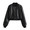 Jaqueta feminina de couro Charm preta, estilo bomber cropped com gola, punhos e barra canelados em tom sobre tom, zíper frontal e bolsos discretos, exibindo um luxo moderno e versátil para o estilo exclusivo de Embu das Artes.