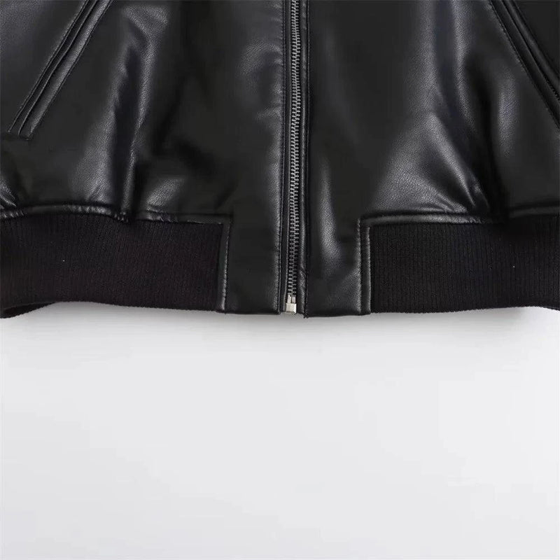 Detalhe da barra canelada e zíper prateado de uma jaqueta de couro feminina Charm preta, evidenciando o acabamento preciso e o material de alta qualidade, um toque de luxo e exclusividade para o estilo em Embu das Artes.