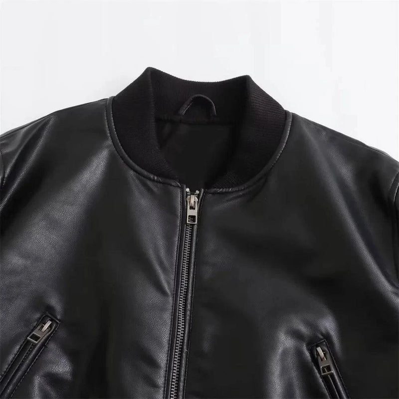 Detalhe da gola canelada e zíper prateado da jaqueta de couro feminina Charm preta, com bolsos laterais, exibindo a textura suave do couro e o acabamento premium da peça de luxo em Embu das Artes.