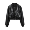 Jaqueta feminina de couro clássica preta, estilo bomber cropped, com acabamento liso, gola, punhos e barra canelados, zíper frontal e bolsos inclinados, exibindo um luxo discreto e atemporal, ideal para o estilo de Embu das Artes.