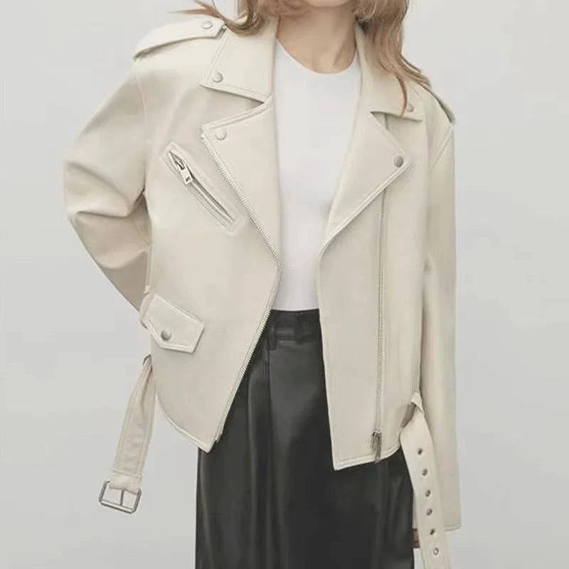 Jaqueta de couro feminina na cor off-white, estilo biker com zíper assimétrico, lapelas largas e cinto ajustável na barra, transmitindo um visual de luxo moderno e distinto.
