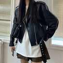Mulher com jaqueta de couro preta estilo biker, manga bufante, sobre camiseta branca e shorts