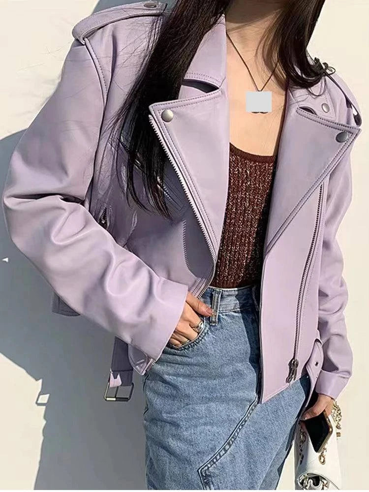 Jaqueta de couro legítimo Attractive na cor lilás pastel, estilo biker com zíper assimétrico e lapelas marcantes, combinada com jeans, conferindo um visual moderno de luxo e personalidade exclusiva.