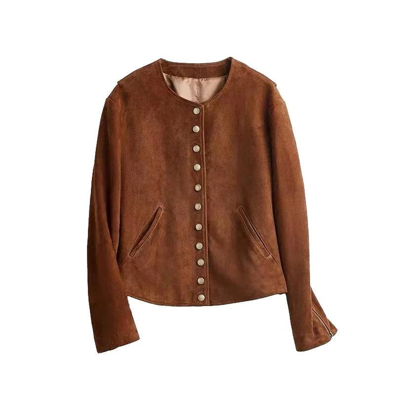 Jaqueta feminina de couro legítimo marrom com acabamento aveludado de camurça, estilo collarless, adornada com botões dourados frontais e bolsos discretos, representando um item de luxo e exclusividade.