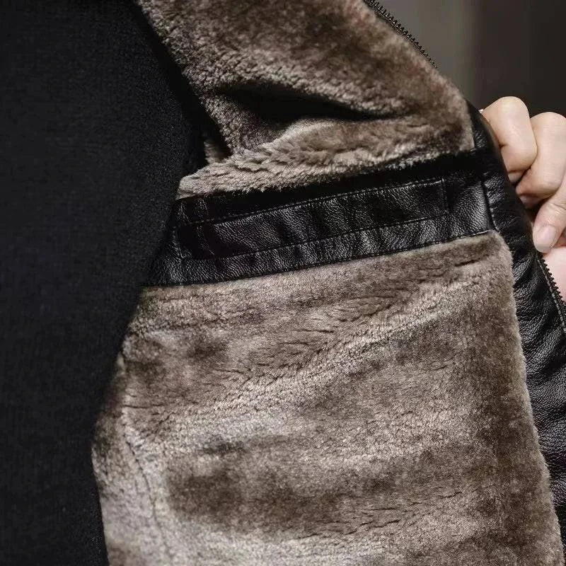 Detalhe aproximado do forro interno de pelúcia macia em tom cinza-marrom da jaqueta de couro preta, mostrando a textura luxuosa do material e o acabamento da costura interna. Conforto premium e calor excepcional.