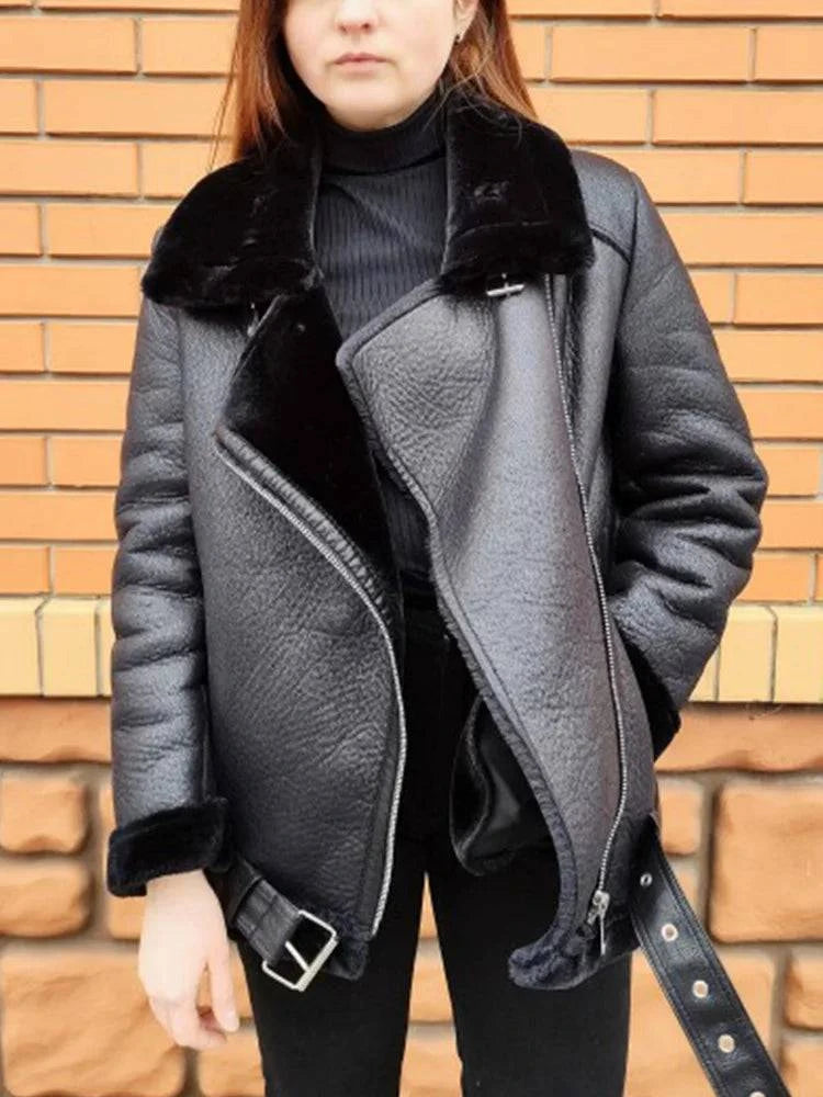 Mulher vestindo jaqueta de couro Rockstar preta com gola e forro de pele sintética, zíper assimétrico aberto e cinto com fivela, exibindo um estilo de luxo urbano e aquecimento de alto padrão.