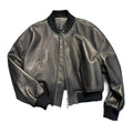 Jaqueta feminina de couro Urban preta, estilo bomber com gola, punhos e barra canelados em tom sobre tom, zíper frontal e bolsos discretos, exibindo um luxo discreto e versátil para o cenário urbano de Embu das Artes.