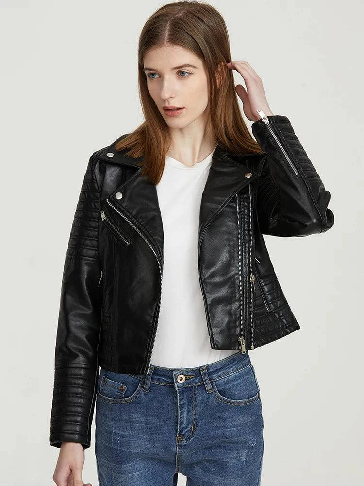 Modelo usando jaqueta de couro feminina Vogue Noir preta, com zíperes assimétricos e detalhes acolchoados nos braços, destacando a textura do couro e o design exclusivo de alta-costura.
