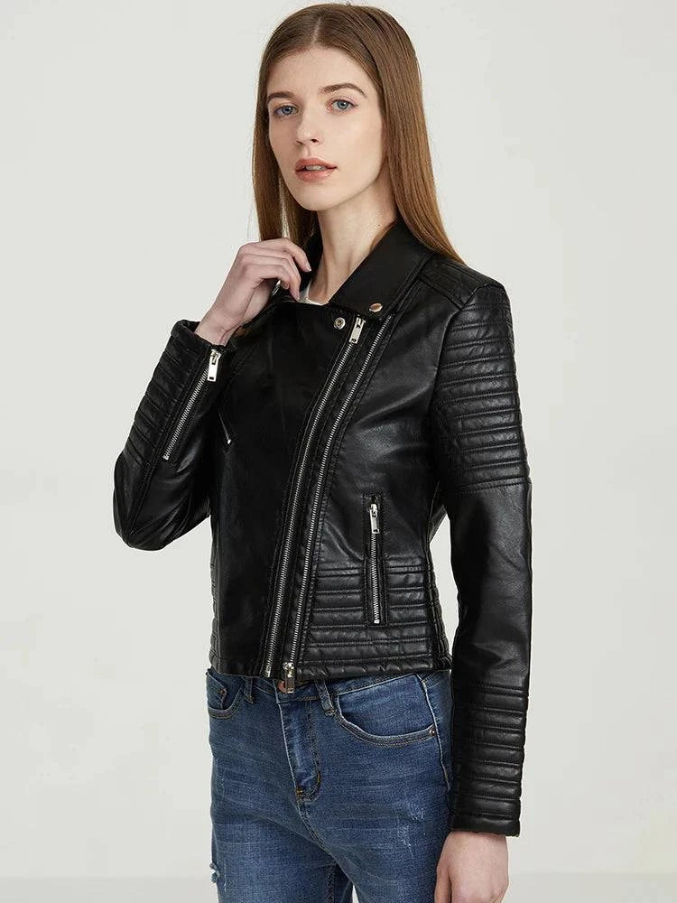 Modelo usando jaqueta de couro feminina Vogue Noir preta, com lapelas, múltiplos zíperes prateados e detalhes acolchoados nas mangas, expressando um estilo premium e contemporâneo.