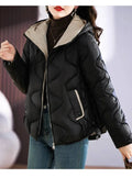 Jaqueta puffer feminina em tom creme claro, com acolchoamento ondulado e capuz forrado em marrom, oferecendo um visual de luxo sutil e aquecimento premium para o inverno.