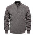Jaqueta masculina bomber acolchoada com corpo em padrão de losangos cinza claro, mangas em tecido cinza escuro (fleece), gola, punhos e barra canelados cinza. Fechamento frontal com botões de pressão. Design moderno e versátil, combinando conforto e exclusividade.