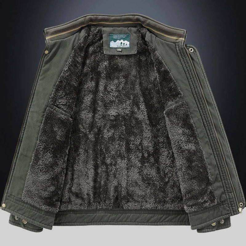 Jaqueta masculina bomber parka verde escuro, aberta para revelar o luxuoso forro de pelúcia em tom cinza escuro, com bolsos internos funcionais e a etiqueta da marca visível. A gola canelada com listras adiciona um toque de estilo, garantindo aquecimento superior e exclusividade para o clima de Embu das Artes.