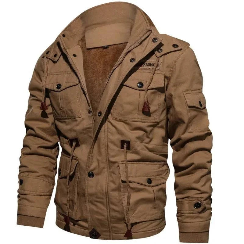 Jaqueta masculina militar forrada na cor cáqui, com gola alta, múltiplos bolsos utilitários com botões e detalhes em couro marrom, aberta para revelar o forro de pelúcia. Uma peça robusta e funcional, combinando durabilidade e um toque de exclusividade, ideal para o estilo de vida aventureiro de Embu das Artes.