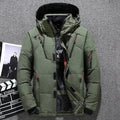 Jaqueta masculina parka acolchoada verde oliva com capuz, múltiplos bolsos frontais com zíperes vermelhos e pretos, e fechamento com botões de pressão e zíper, em um fundo que remete a um estúdio de cinema. Design robusto e funcional para um estilo de alta performance