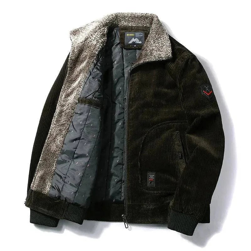 Jaqueta masculina de veludo cotelê verde escuro, ligeiramente aberta para revelar o forro interno acolchoado preto e a gola de pele sintética em tons de cinza e marrom. Possui fechamento frontal com zíper e bolsos laterais. Uma peça luxuosa e quente, ideal para um estilo sofisticado e exclusivo no inverno de Embu das Artes.