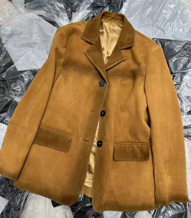 Jaqueta de pele de carneiro vintage feminina caramelo, estilo blazer com botões pretos e bolsos frontais, exibindo a textura aveludada do material premium e o forro interno, conferindo um luxo atemporal e exclusivo.