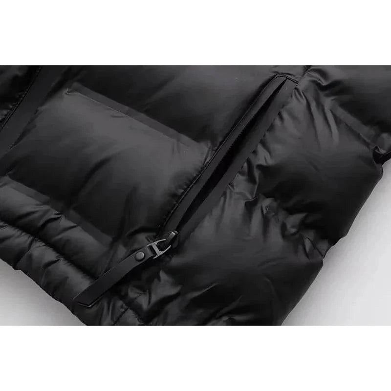 Detalhe do bolso com zíper e fecho da jaqueta puffer feminina preta, destacando a praticidade e o acabamento sofisticado do design.