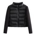 Jaqueta puffer feminina preta com gola alta, detalhes em tecido liso nas mangas e acolchoamento central, exibindo o design moderno e aquecimento premium.