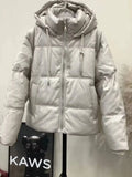 Jaqueta puffer feminina para inverno em tom bege claro, com capuz e zíper prateado, evidenciando o design moderno e o isolamento térmico premium para o frio.