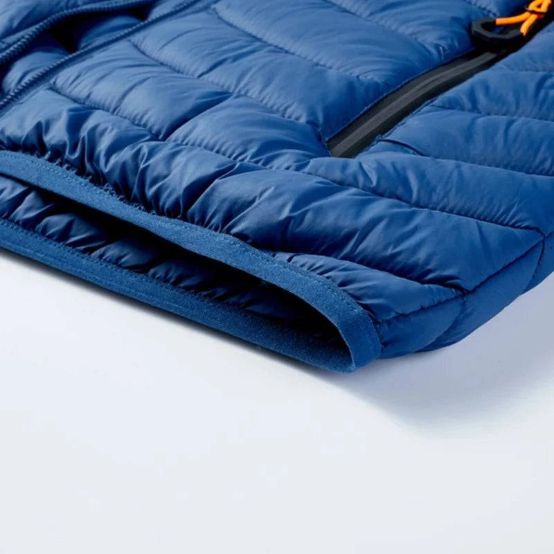 Close-up da barra inferior da jaqueta puffer masculina azul royal, mostrando o acabamento elástico interno em azul escuro e a costura acolchoada. A funcionalidade discreta realça a qualidade superior da peça, ideal para um aquecimento de luxo em Embu das Artes.