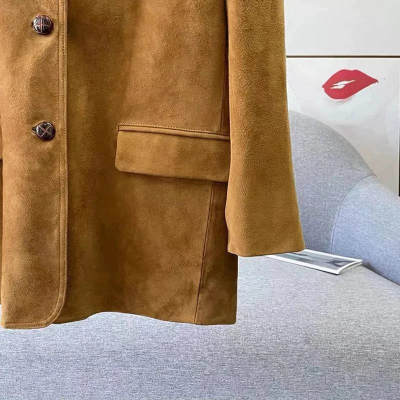 Detalhe de perto da jaqueta retro feminina de pele de carneiro caramelo, mostrando a textura aveludada, botões de design e bolso frontal, evidenciando o acabamento impecável e o luxo vintage do material exclusivo.