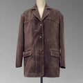 Jaqueta retro feminina de pele de carneiro em tom marrom escuro aveludado, estilo blazer com três botões e bolsos frontais, exibida em manequim, destacando o luxo vintage e a qualidade superior do material.