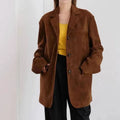 Mulher usando jaqueta retro feminina de pele de carneiro marrom, estilo blazer oversized com botões, combinada com blusa amarela e calça preta, exibindo um visual de luxo vintage e exclusivo em Embu das Artes.