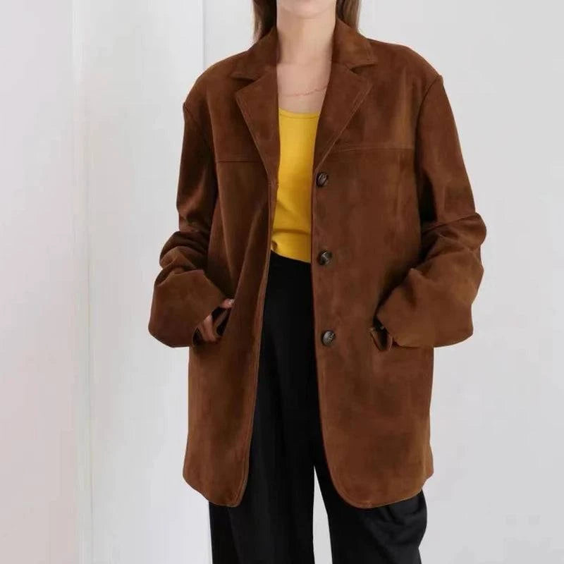 Mulher usando jaqueta retro feminina de pele de carneiro marrom, estilo blazer oversized com botões, combinada com blusa amarela e calça preta, exibindo um visual de luxo vintage e exclusivo em Embu das Artes.