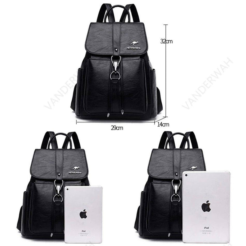 Mochila e bolsa feminina de couro 2 em 1 preta, exibindo dimensões de 29cm de largura, 32cm de altura e 14cm de profundidade, com comparativo de tamanho com um iPad.