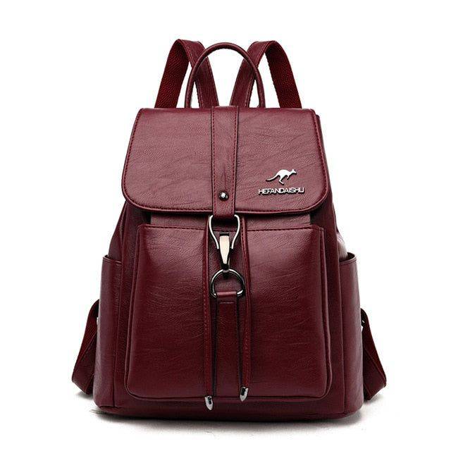 Mochila e bolsa feminina de couro 2 em 1 na cor vinho, com aba superior, fecho de gancho metálico e logotipo de canguru, destacando seu design elegante e funcional.