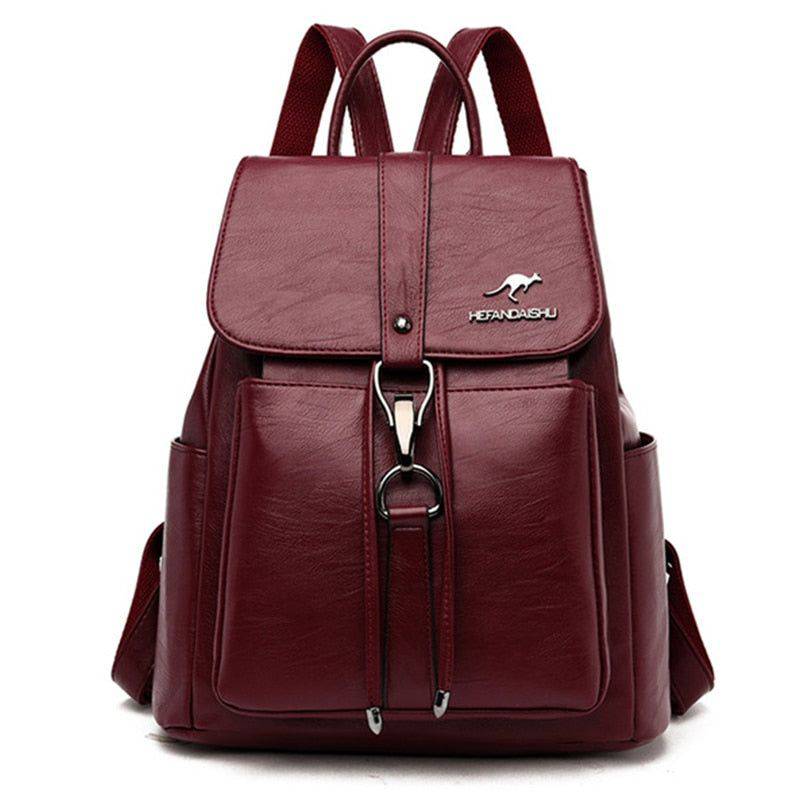 Mochila e bolsa feminina de couro 2 em 1 na cor vinho, com aba frontal, fecho de gancho e bolsos laterais, design versátil com alças ajustáveis.