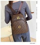 Mochila feminina marrom com monograma MK e detalhes dourados, usada como mochila de costas