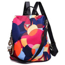 Mochila com estampa geométrica abstrata em tons vibrantes, alças pretas e chaveiro de urso