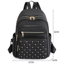 Mochila nylon preta com bolsos acolchoados e tachas brancas, alças ajustáveis e zíperes dourados