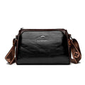 Shoulder Bag Bolsa Feminina de Couro preta, com design de dois tons e alça estampada larga. Logo metálico de canguru. Elegante e versátil.