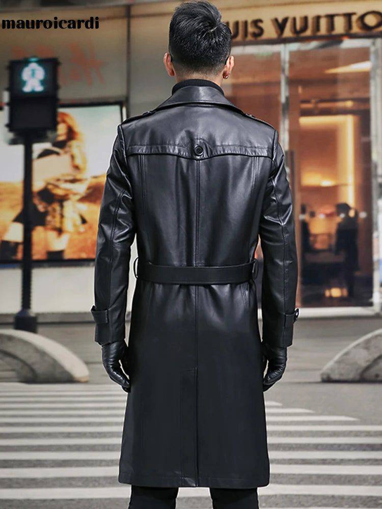 Costas do sobretudo masculino Zellum longo em couro genuíno preto, com cinto e detalhes de design, em frente a loja de luxo, evocando exclusividade.