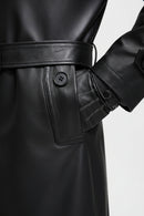 Detalhe do bolso lateral, cinto e punho com botão de sobretudo de couro preto