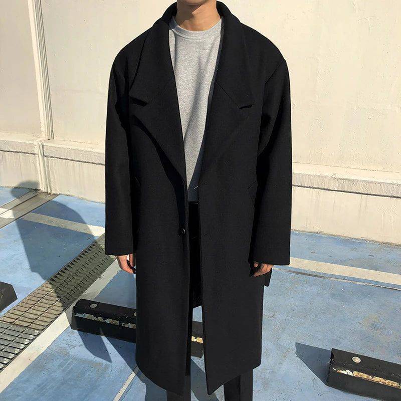 Sobretudo masculino Zellum longo de lã preta, com 2 botões, aberto, sobre suéter cinza e calça escura, estilo minimalista e versátil.