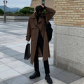 Sobretudo masculino Zellum longo marrom liso, de algodão e poliéster, sobre gola alta preta, com mochila e sacola de compras, em ambiente urbano moderno.
