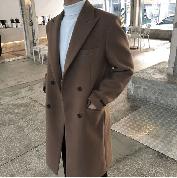 Sobretudo masculino Zellum Longo Mid marrom-café, com botões duplos e bolso aparente, sobre gola alta branca, em ambiente moderno, estilo sofisticado.