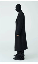 Sobretudo masculino longo preto, vista lateral, com caimento fluido e colarinho alto