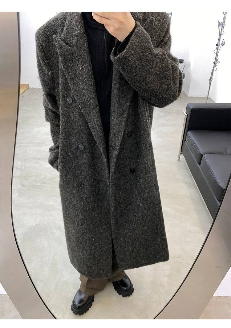 Detalhe frontal do sobretudo masculino longo cinza com tecido encorpado e lapela clássica, ideal para moda masculina sofisticada.
