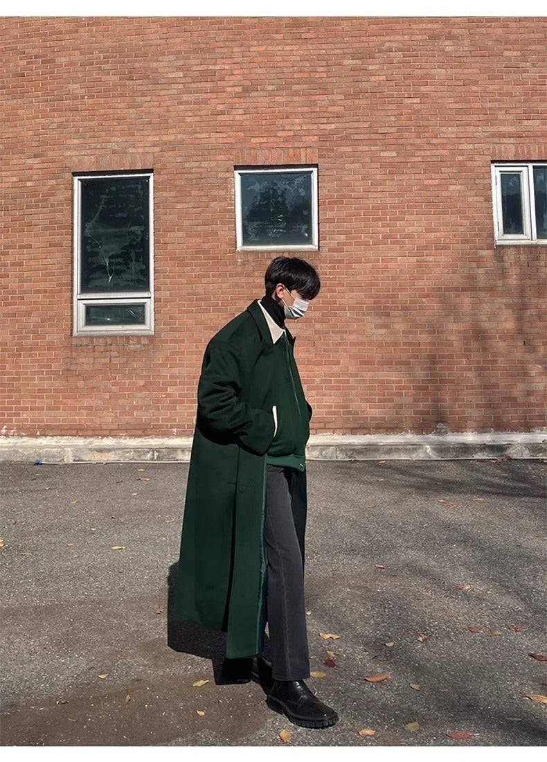 Homem caminhando com sobretudo masculino longo verde, ideal para dias frios com estilo clássico e casual.
