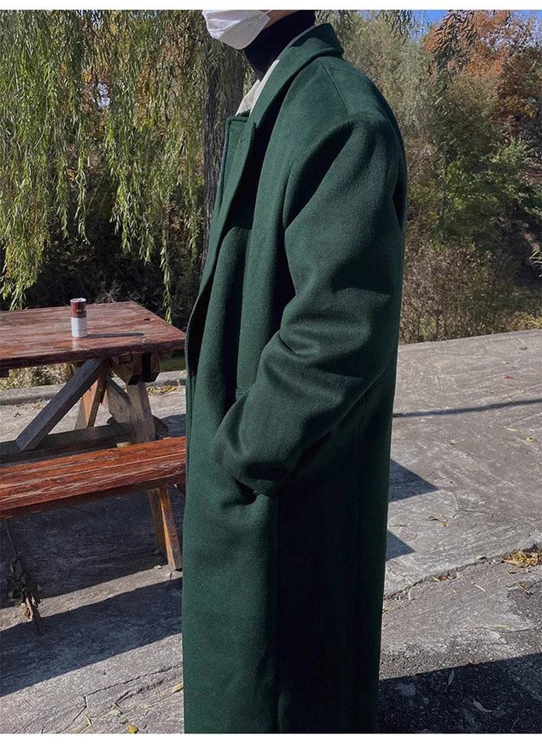 Perfil lateral do sobretudo masculino verde em ambiente externo, combinando com looks casuais de outono/inverno.